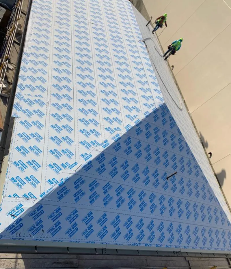 Professional roofers installing underlayment on a metal roof in Iowa City